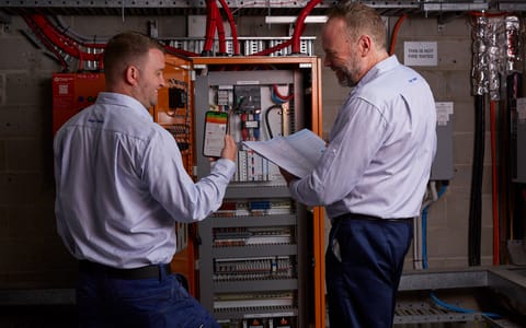Two man in front of machinery