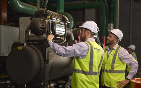 Two man in front of machinery