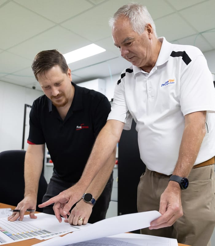 Two men in front of plans